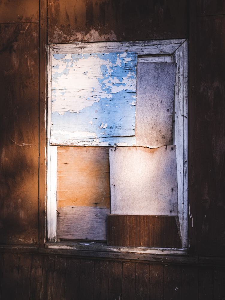 Boarded-up window on a weathered building